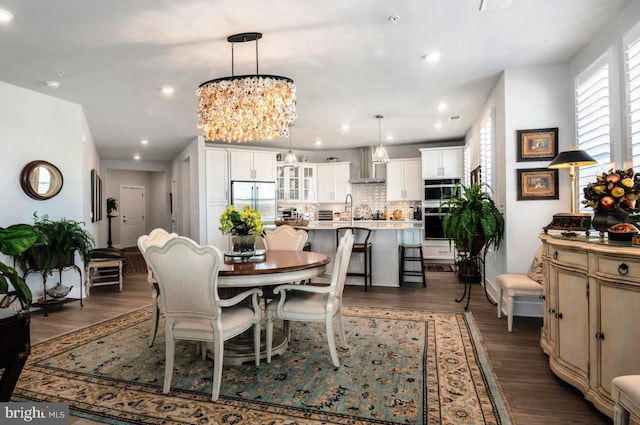 dining space featuring a notable chandelier, dark wood-type flooring, and sink