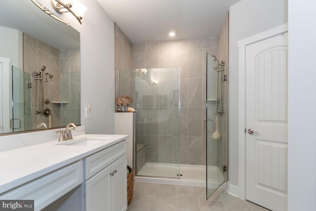 bathroom with a shower with door, tile patterned flooring, and vanity