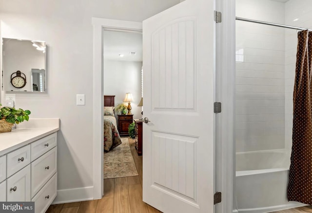 bathroom with shower / bathtub combination with curtain, vanity, and wood-type flooring