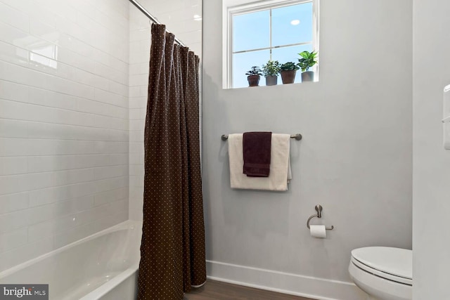 bathroom with toilet, wood-type flooring, and shower / bath combo