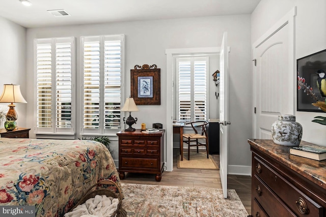 bedroom with light hardwood / wood-style flooring and multiple windows