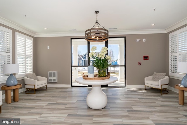 living area with a notable chandelier, crown molding, and heating unit