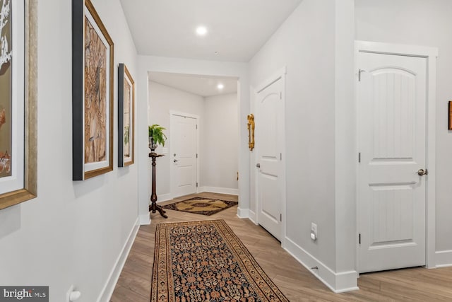 corridor with light hardwood / wood-style floors