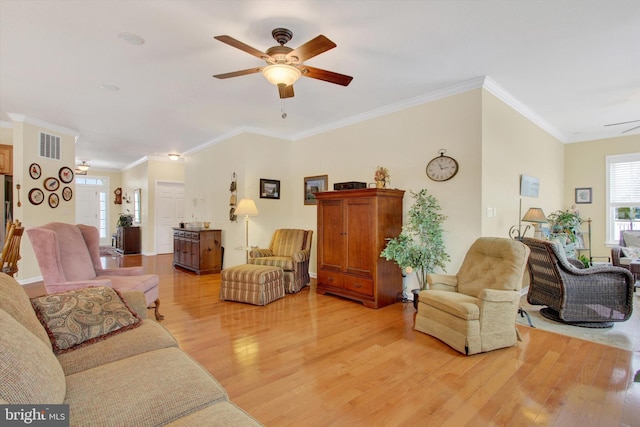 living room with crown molding, light hardwood / wood-style flooring, and ceiling fan