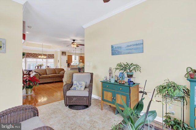 living room with light hardwood / wood-style floors, ceiling fan, and ornamental molding