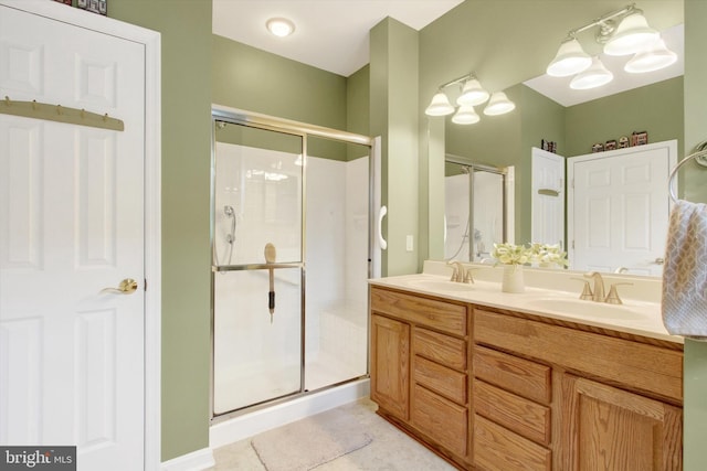 bathroom with a chandelier, vanity, tile patterned floors, and an enclosed shower