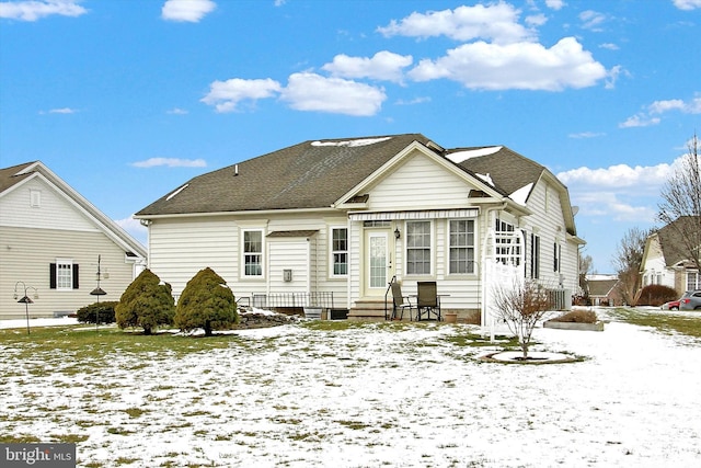 snow covered rear of property featuring central air condition unit