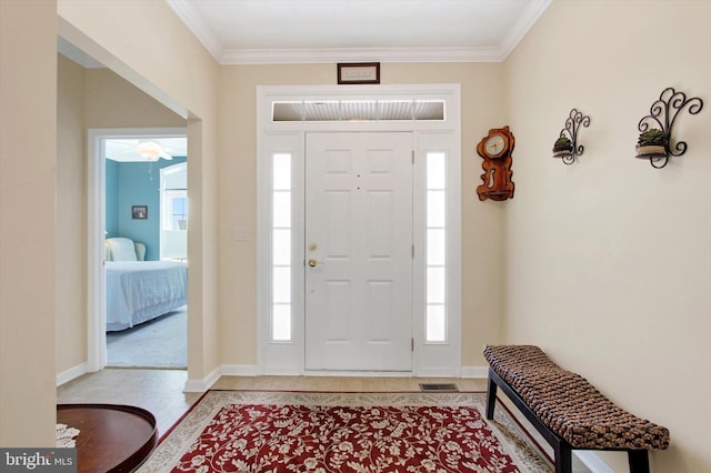 foyer with ceiling fan and ornamental molding