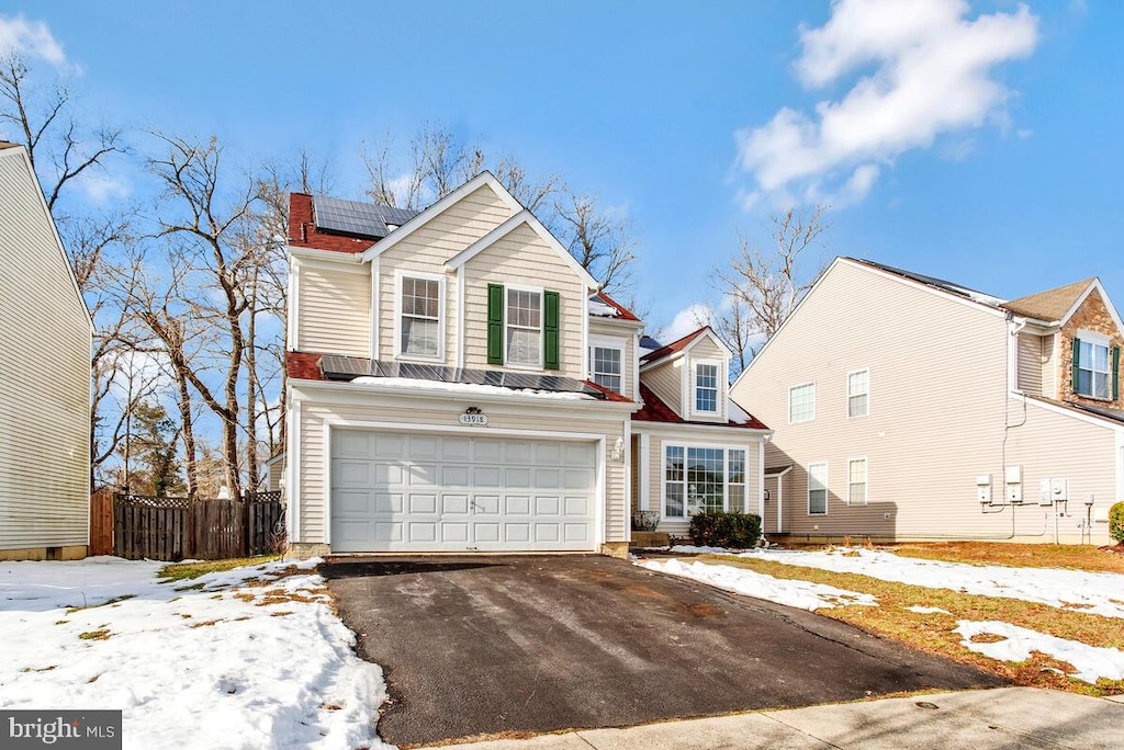 view of property featuring solar panels and a garage