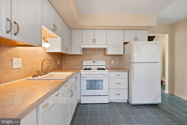 kitchen with backsplash, sink, white appliances, white cabinets, and dark tile patterned floors