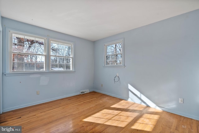 spare room featuring light hardwood / wood-style floors and plenty of natural light