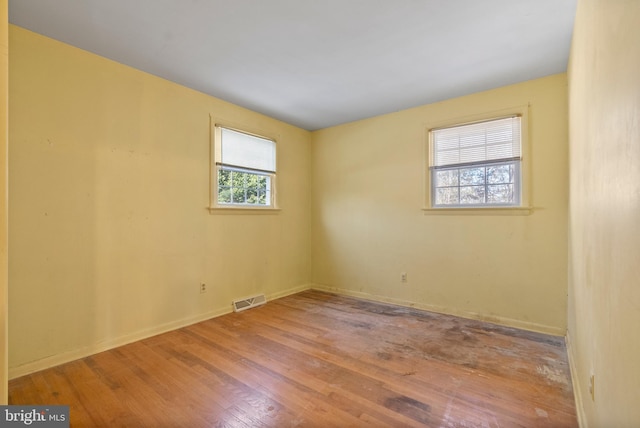 empty room with a healthy amount of sunlight and light hardwood / wood-style flooring