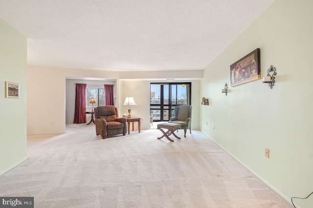 sitting room featuring light colored carpet and a textured ceiling