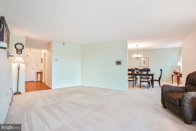 living room with light carpet and a notable chandelier