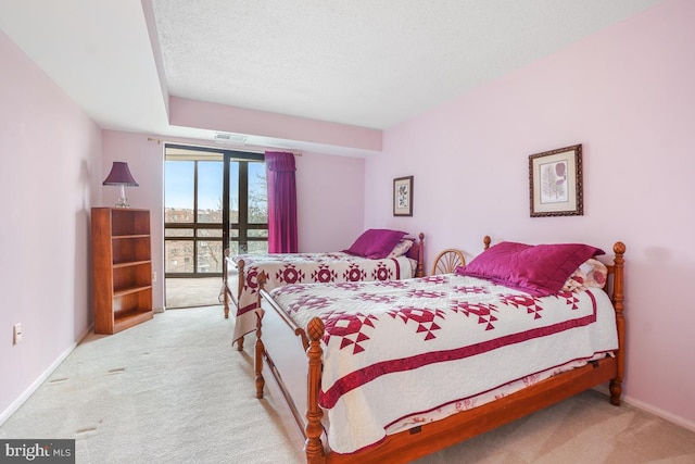 carpeted bedroom with access to outside and a textured ceiling