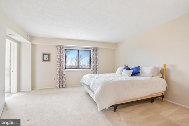 bedroom featuring light colored carpet and a textured ceiling