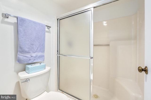 bathroom with an enclosed shower and toilet