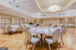 dining space with beamed ceiling, light parquet flooring, coffered ceiling, and a chandelier