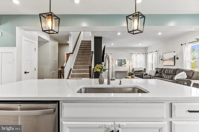 kitchen featuring white cabinets, pendant lighting, and sink