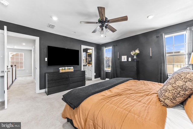 carpeted bedroom featuring ensuite bath and ceiling fan