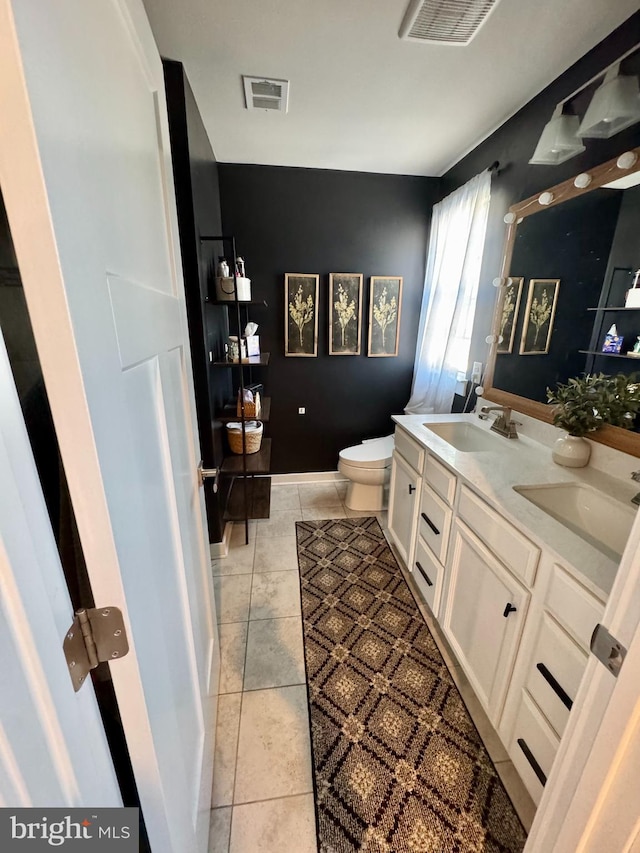 bathroom with toilet, tile patterned floors, and vanity