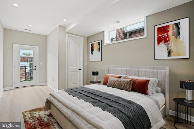 bedroom with light wood-type flooring and access to exterior