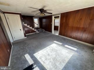 interior space featuring dark carpet and wood walls