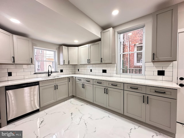 kitchen with gray cabinetry, dishwasher, backsplash, and sink