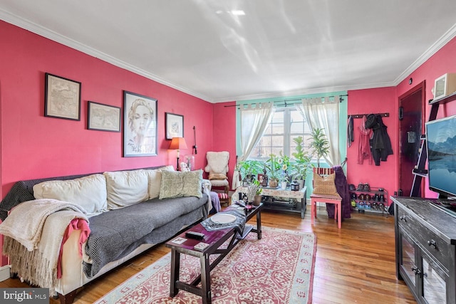 living area with ornamental molding and wood finished floors