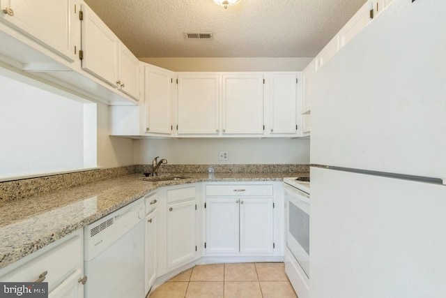 kitchen featuring white appliances, a textured ceiling, light stone counters, white cabinets, and sink