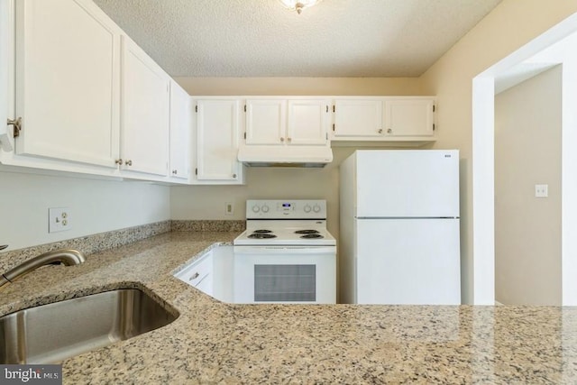 kitchen with white appliances, light stone countertops, a textured ceiling, white cabinetry, and sink