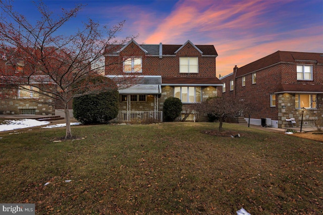 view of front of property featuring cooling unit and a lawn