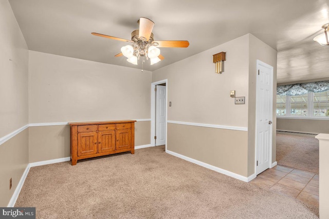 unfurnished room with a baseboard heating unit, light carpet, and ceiling fan