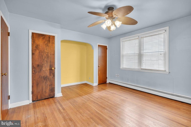 unfurnished bedroom featuring a baseboard radiator, ceiling fan, and light hardwood / wood-style flooring