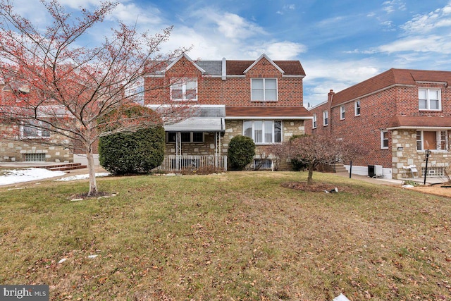 view of front of home with a front yard and central AC