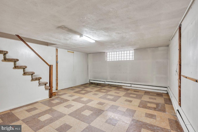 basement with a baseboard heating unit and a textured ceiling