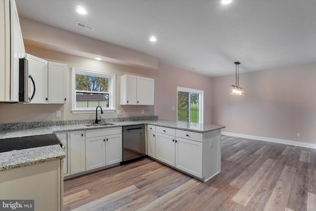 kitchen featuring hanging light fixtures, light stone countertops, kitchen peninsula, black dishwasher, and white cabinetry