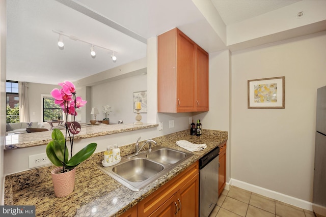 kitchen with light stone countertops, light tile patterned floors, stainless steel dishwasher, and sink