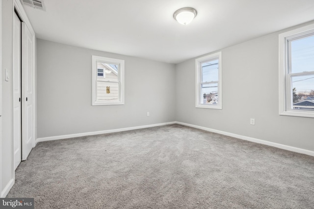 unfurnished bedroom with multiple windows and carpet