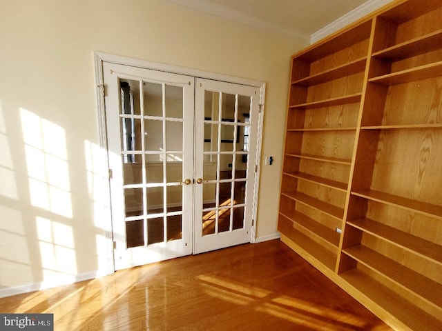 entryway with ornamental molding, french doors, and wood-type flooring