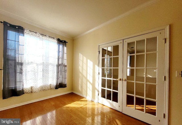 spare room featuring ornamental molding, french doors, and light wood-type flooring