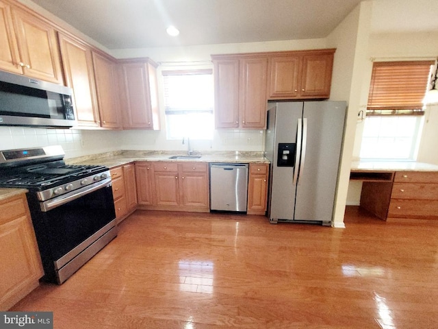 kitchen with sink, light brown cabinets, decorative backsplash, and appliances with stainless steel finishes