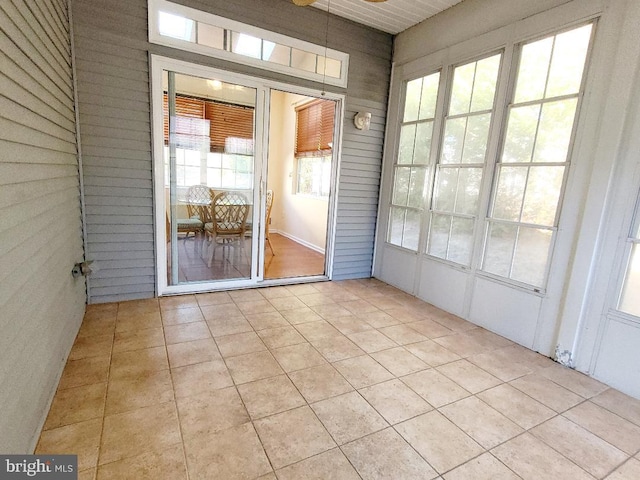 unfurnished sunroom featuring ceiling fan