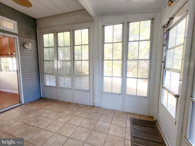 unfurnished sunroom with ceiling fan