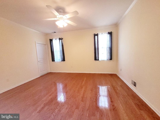 empty room featuring hardwood / wood-style flooring, ceiling fan, and ornamental molding