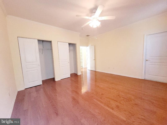 unfurnished bedroom with ceiling fan, dark hardwood / wood-style flooring, and ornamental molding