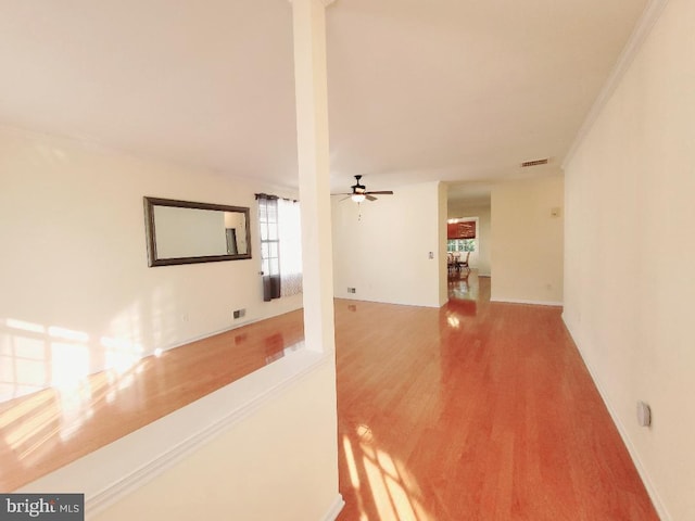 corridor with wood-type flooring and crown molding