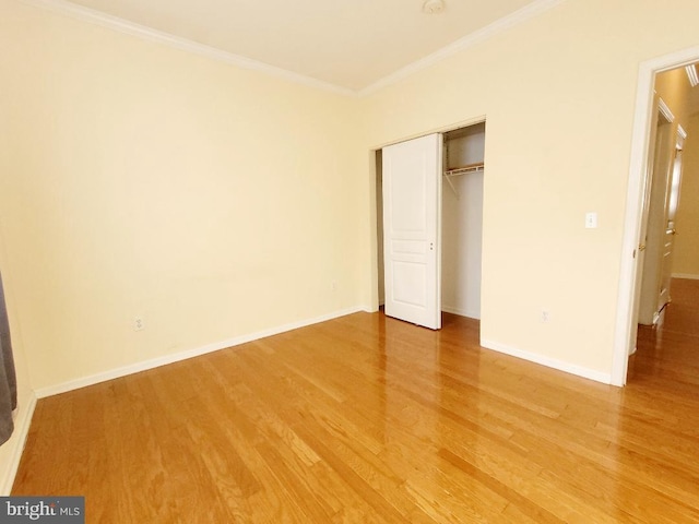 unfurnished bedroom featuring a closet, crown molding, and wood-type flooring