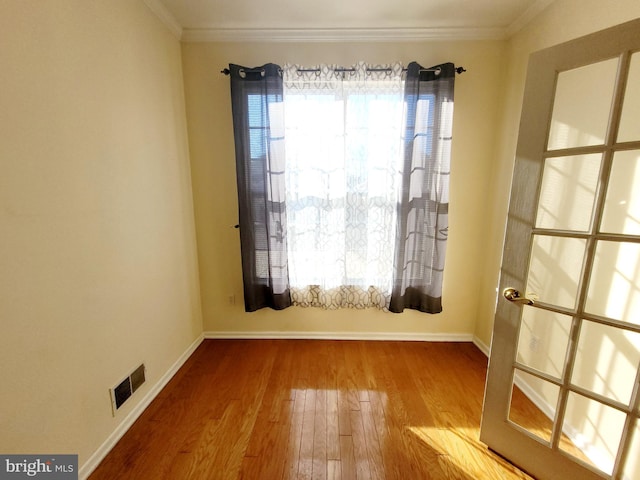 spare room with crown molding and hardwood / wood-style floors