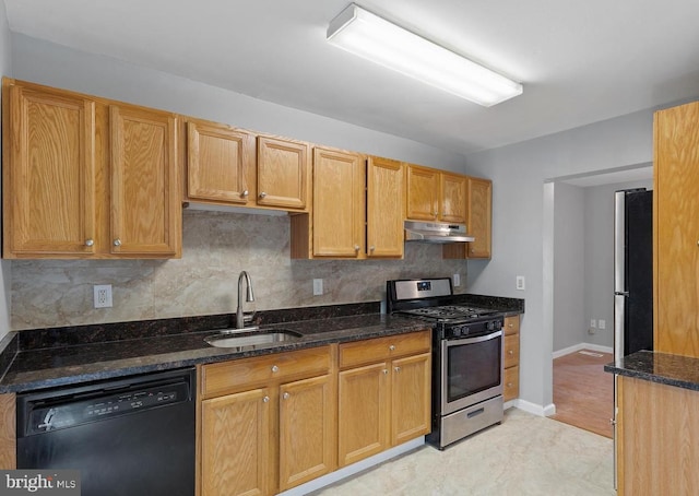 kitchen featuring light tile patterned floors, sink, appliances with stainless steel finishes, and dark stone counters